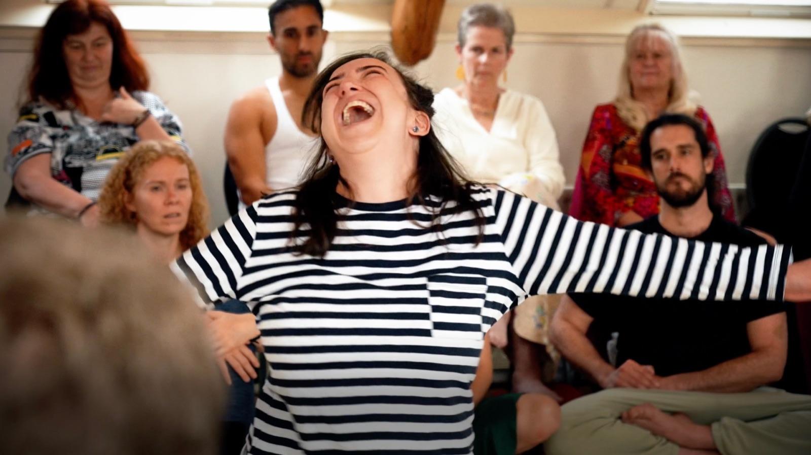 A woman laughing with her arms wide inside a Heart iQ circle