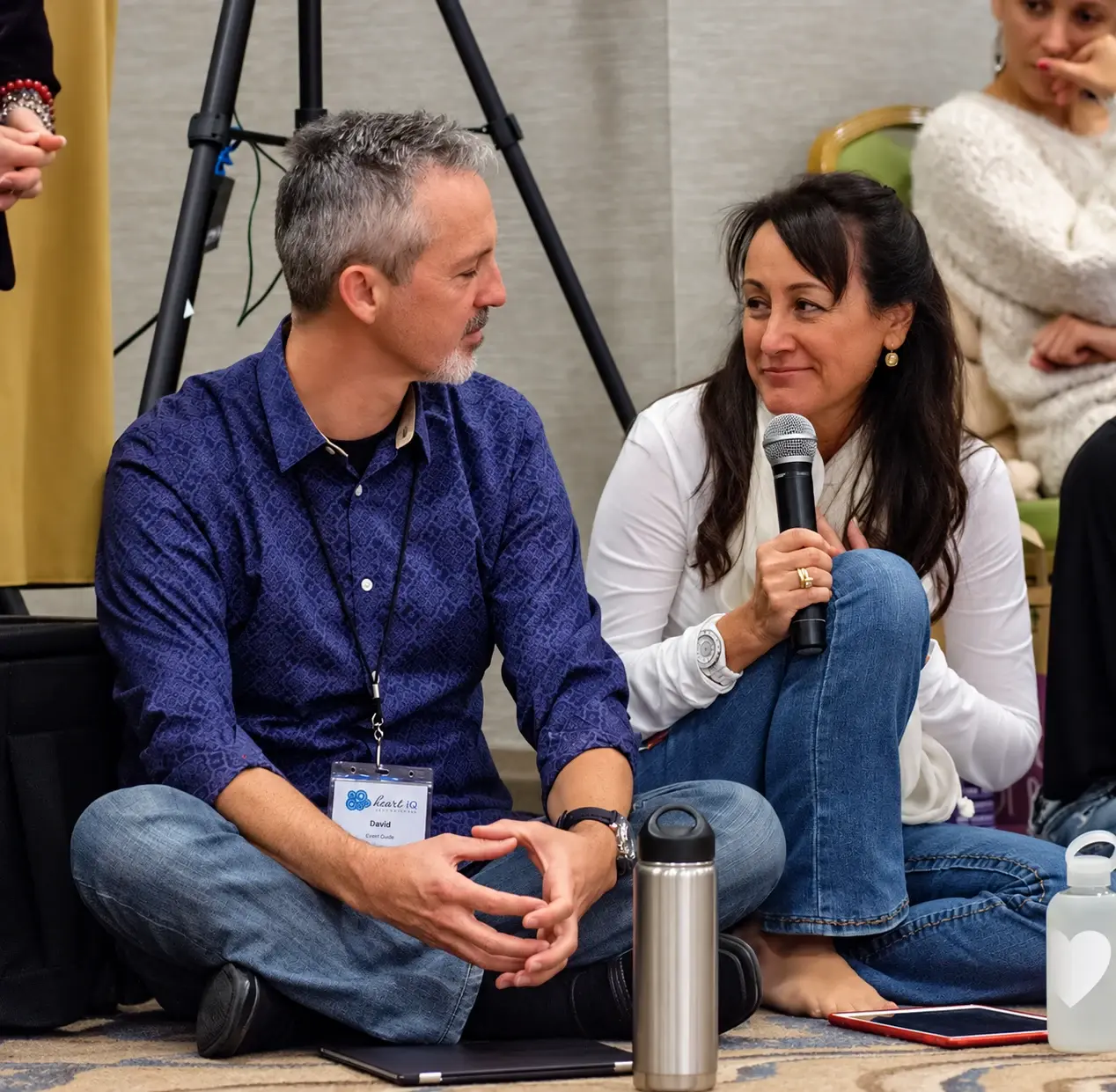 A woman speaking into a microphone beside her partner