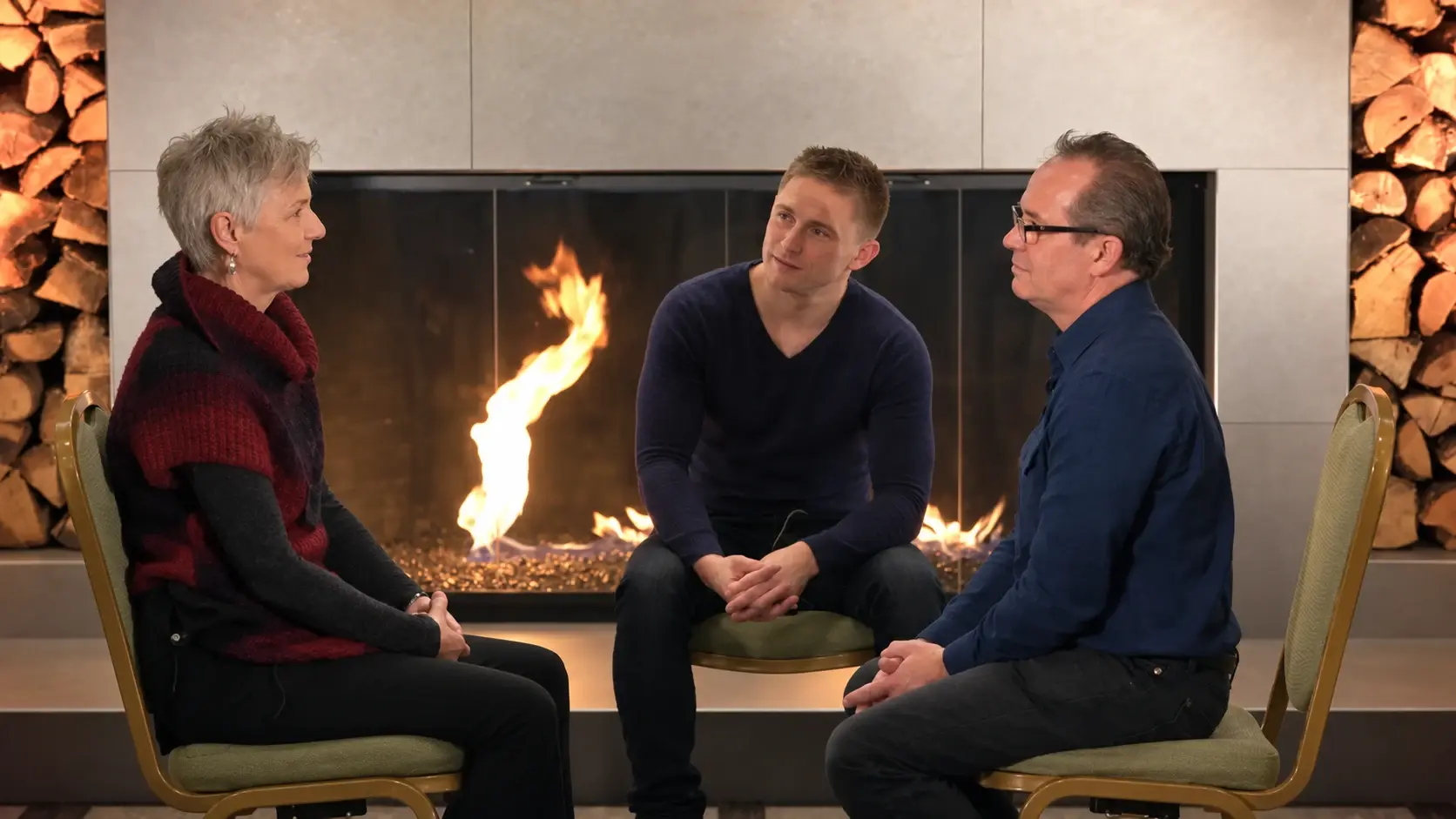 Christian listening to a couple beside the fireplace