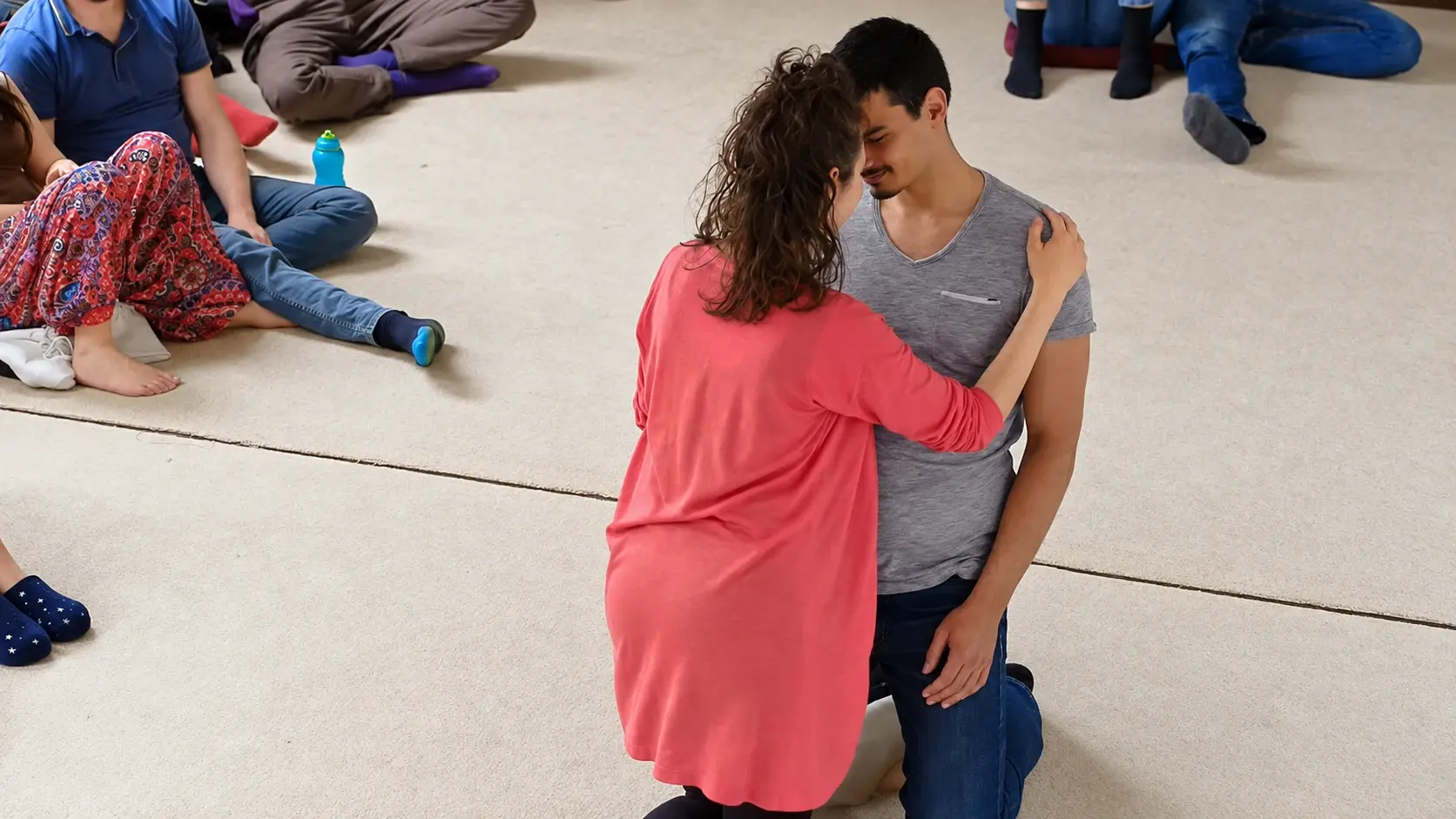 Two partners meeting forehead to forehead in a movement practice