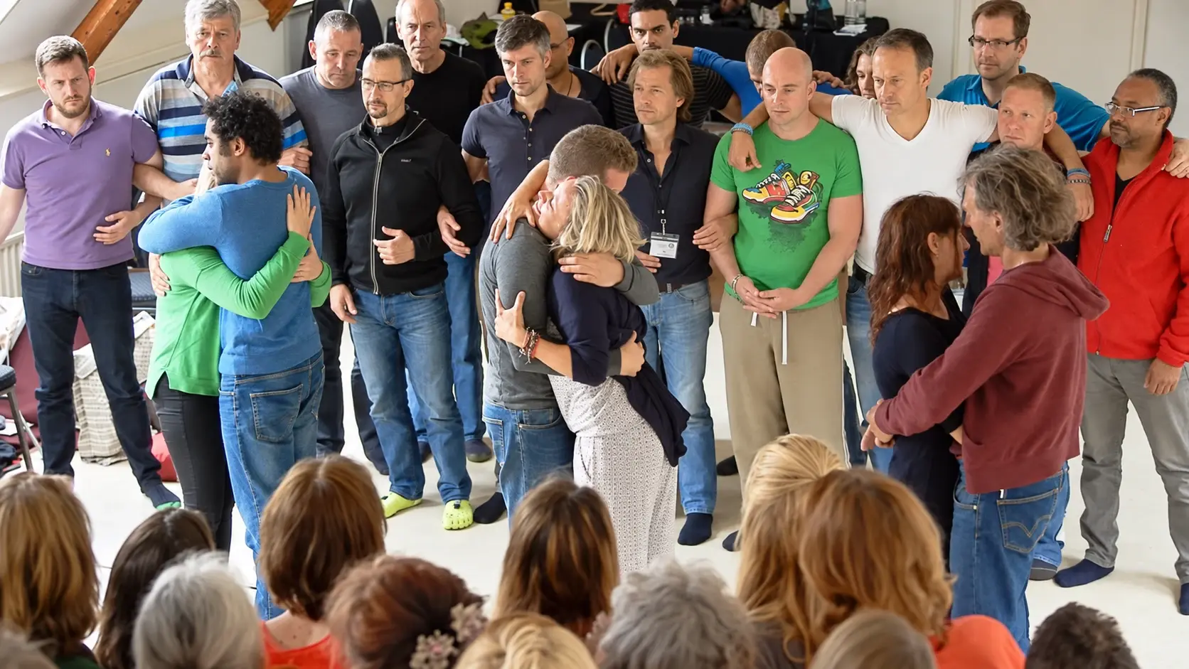 Couples embracing within a standing group