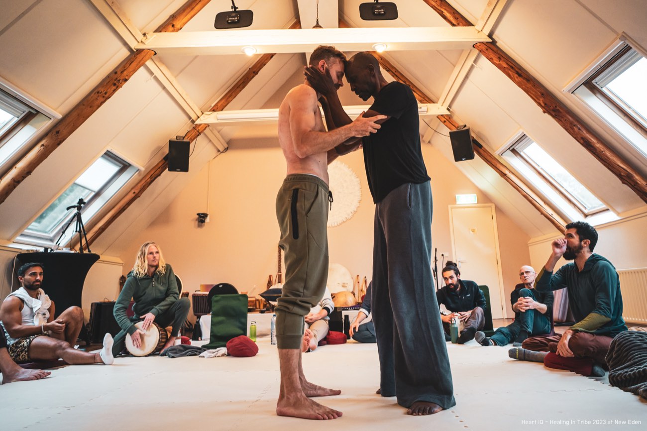 Two men forehead to forehead as an encounter completes at Healing in Tribe, New Eden