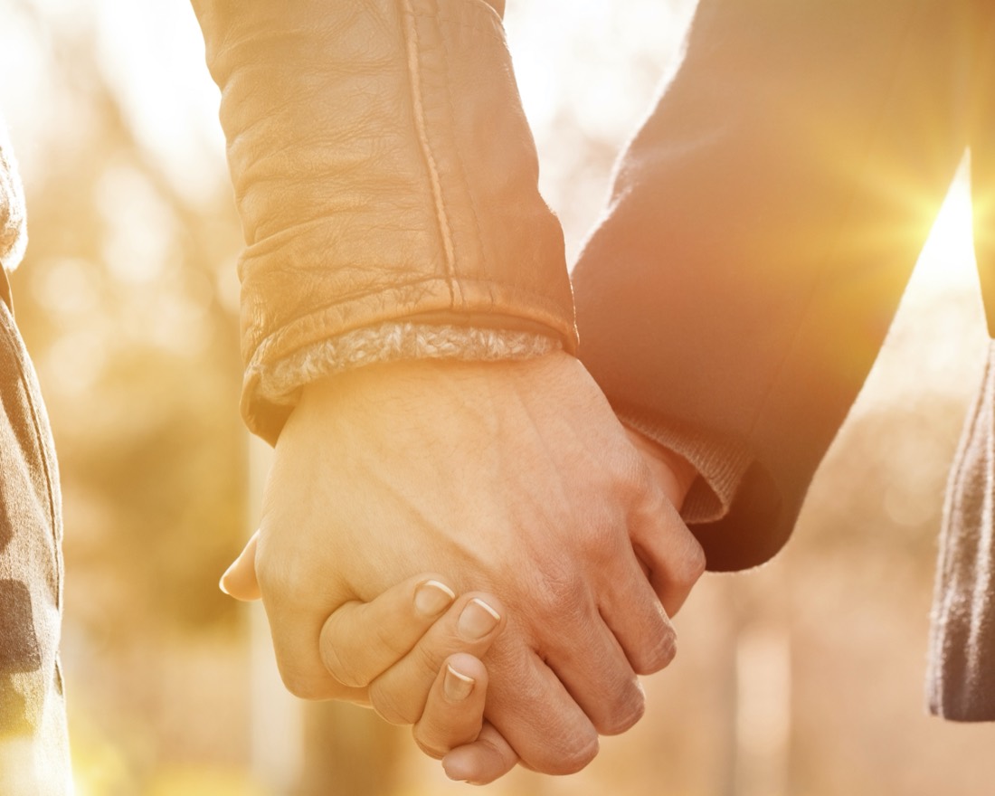 A couple holding hands at golden hour